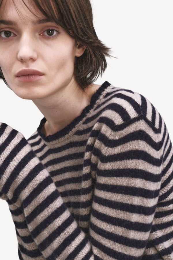 Front closeup view of navy/oat sibs stripe sweater on model, against a white background.