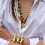 18K YG and Black Ebony Link Necklace on white background, with model wearing a white shirt and the necklace combined with other tubular necklaces and bracelets