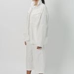 Side view of snow buck ls shirt on model wearing white shirt and pants, against a white background.