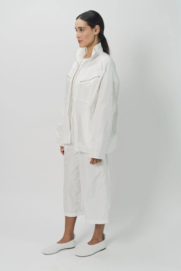 Side view of snow buck ls shirt on model wearing white shirt and pants, against a white background.