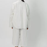 Back view of snow buck ls shirt on model wearing white shirt and pants, against a white background.