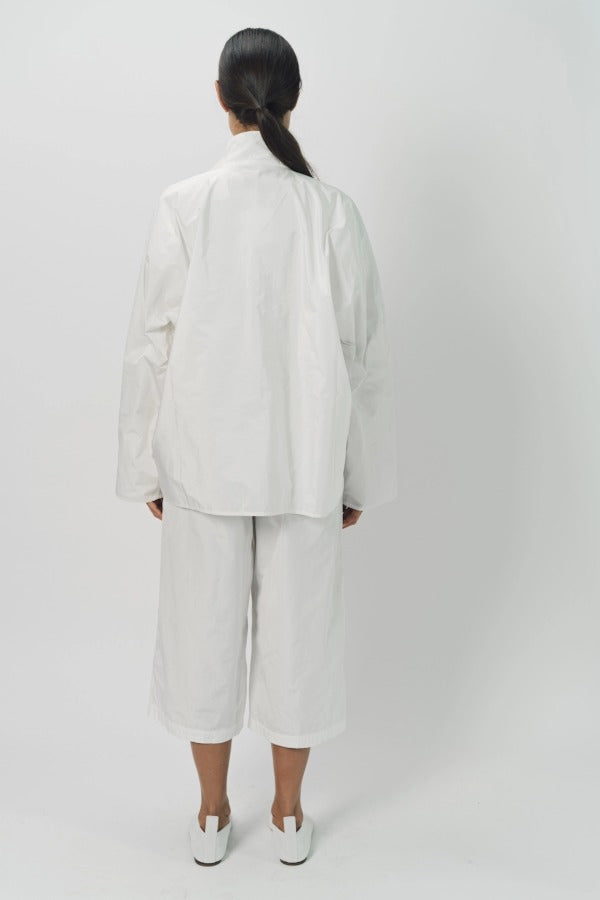 Back view of snow buck ls shirt on model wearing white shirt and pants, against a white background.