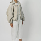Side view of desert colima zip up hoodie on model wearing white shirt and pants, against a white background.