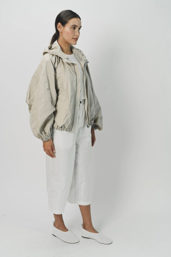 Side view of desert colima zip up hoodie on model wearing white shirt and pants, against a white background.
