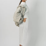 Alternate Side view of desert colima zip up hoodie on model wearing white shirt and pants against a white background.