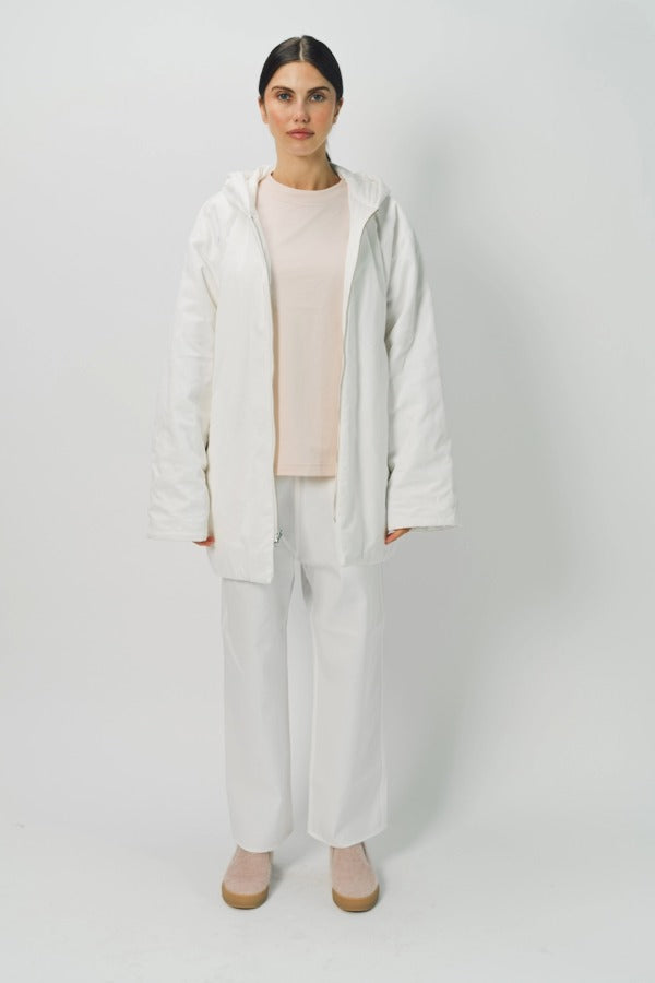 Front view of off white condor rev jacket on model wearing white pants and pink shirt, against a white background.