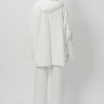 Back view of off white condor rev jacket on model wearing white pants, against a white background.
