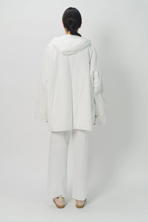 Back view of off white condor rev jacket on model wearing white pants, against a white background.