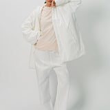 Alternate front view of off white condor rev jacket on model wearing white pants, against a white background.