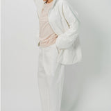 Hooded view of off white condor rev jacket on model wearing white pants and pink shirt, against a white background.