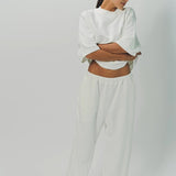Front view of off white tower sweatpants on model wearing white sweatshirt, against a white background.