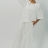 Alternate front view of off white tower sweatpants on model wearing white sweatshirt, against a white background.