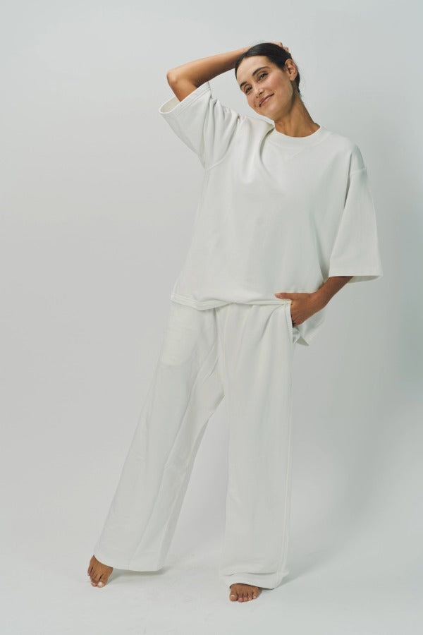 Alternate front view of off white tower sweatpants on model wearing white sweatshirt, against a white background.