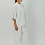Side view of off white tower sweatpants on model wearing white sweatshirt, against a white background.