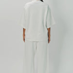 Back view of off white tower sweatpants on model wearing white sweatshirt, against a white background.