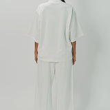 Back view of off white tower sweatpants on model wearing white sweatshirt, against a white background.
