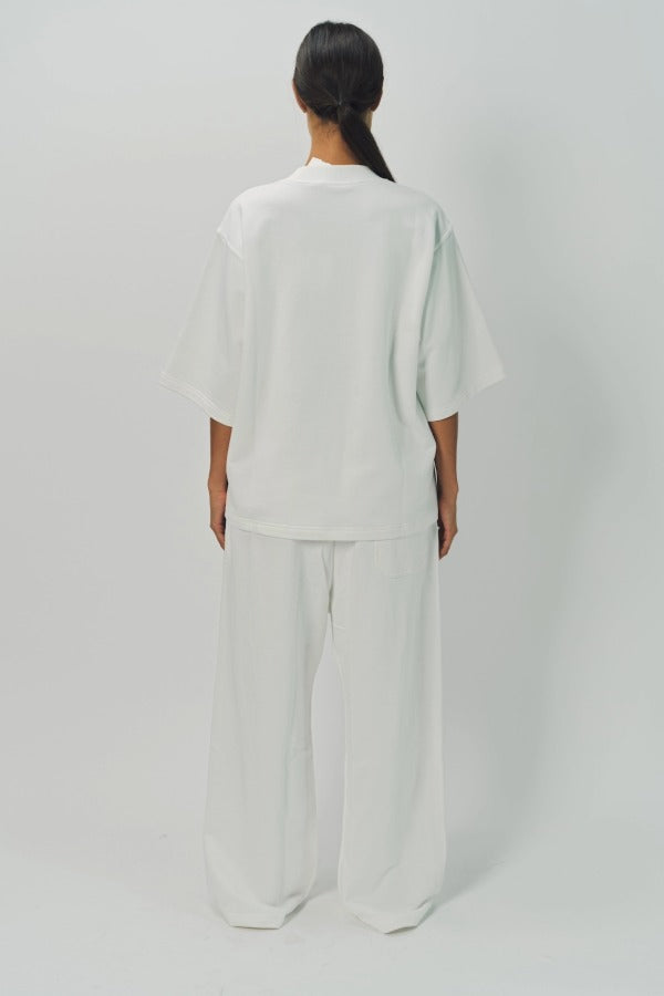Back view of off white tower sweatpants on model wearing white sweatshirt, against a white background.