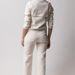 Back view of white my way jacket on model wearing white leather pants and black sandals, against a white background.