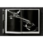 Open view of taschen helmut newton's Legacy book on black background.