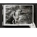 Open view of taschen helmut newton's Legacy book on black background.