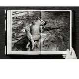Open view of taschen helmut newton's Legacy book on black background.