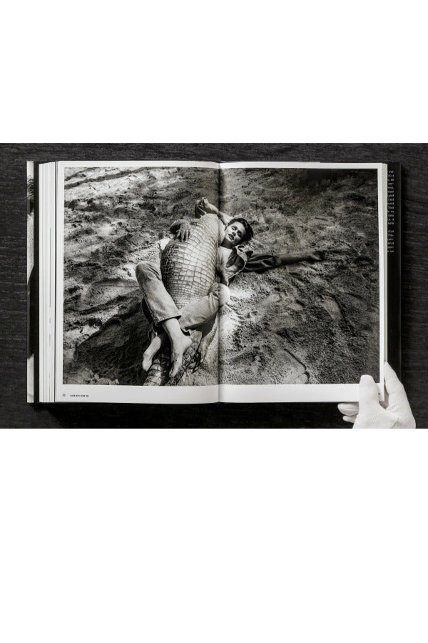 Open view of taschen helmut newton's Legacy book on black background.