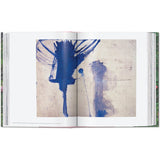 Open book view of taschen julian schnable book on white background.
