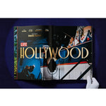 Open book view of taschen life hollywood book on blue background.