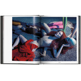 Open view of taschen mert atlas and marcus pigott book on white background.