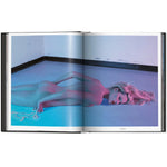 Open view of taschen mert atlas and marcus pigott book on white background.