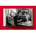Open book view of taschen valentino book on red background.