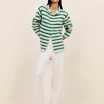 Front view of fern/white costeau stripe cardigan on model wearing white pants and heels, against a white background.