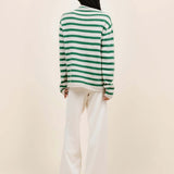 Back view of fern/white costeau stripe cardigan on model wearing white pants and heels, against a white background.