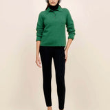 Front view of fern laurel polo on model wearing black leggings, white heels and a beanie against a white background.