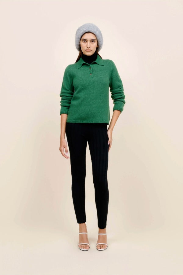 Front view of fern laurel polo on model wearing black leggings, white heels and a beanie against a white background.