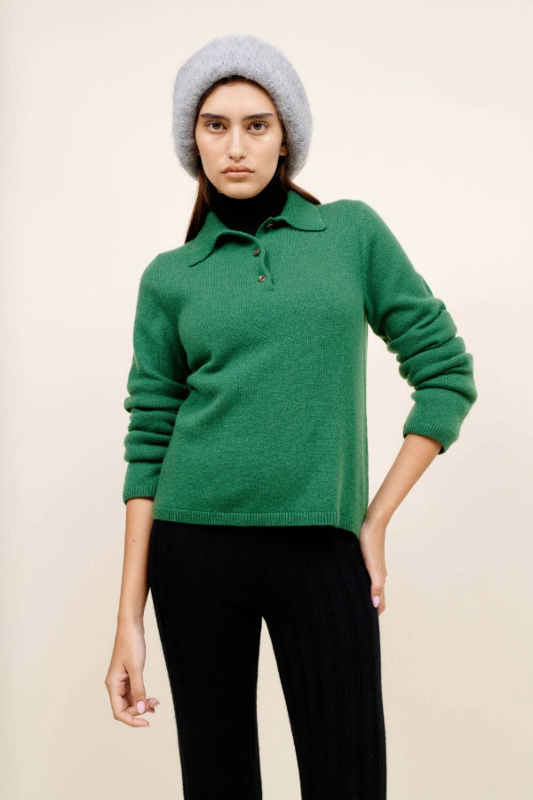 Front closeup view of fern laurel polo on model wearing black leggings and a beanie, against a white background