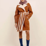 Front view of bordeaux marl triangle body scarf on model wearing orange coat, blue socks and white heels, against a white background.