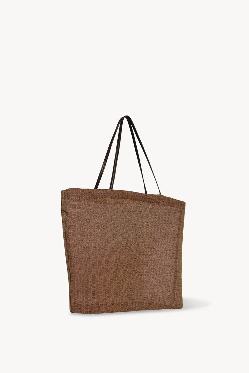 Side slanted view of mesh and leather bag in acero on white background, with no model shown.