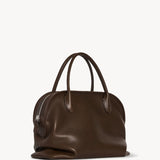 Front slanted view of deep brown agnes bag on white background with no model shown.