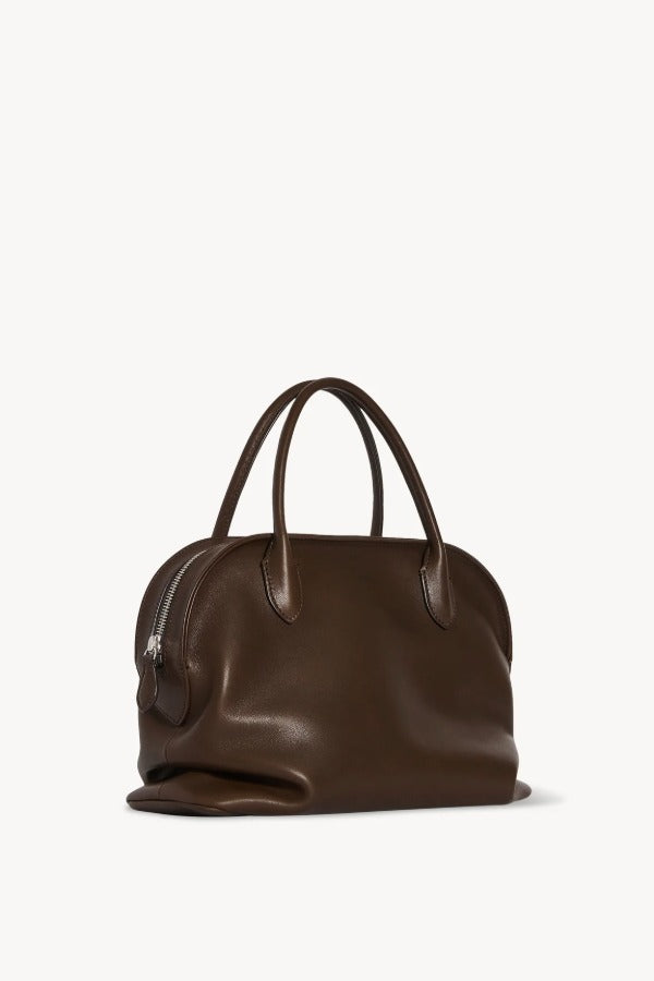 Front slanted view of deep brown agnes bag on white background with no model shown.
