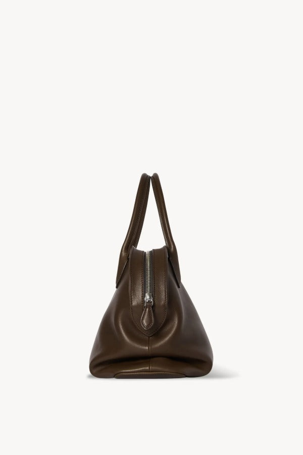 Side view of deep brown agnes bag on white background, with no model shown.