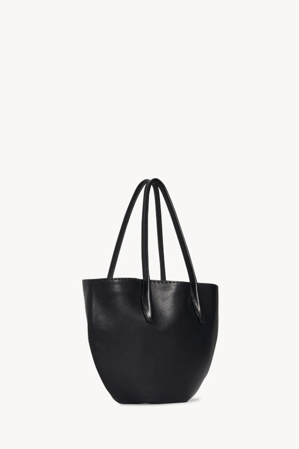 Side slanted view of black alger tote on white background, with no model shown.