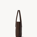 Side view of deep brown alger tote on white background, with no model shown.