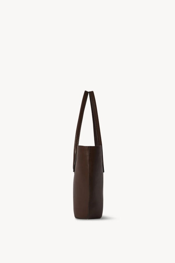 Side view of deep brown alger tote on white background, with no model shown.