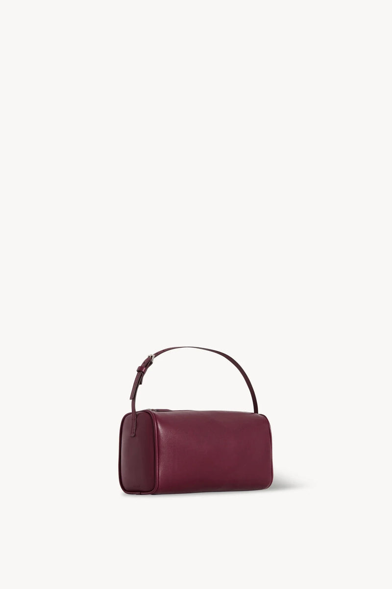 Side slanted view of a purple leather bag on a white background, with no model shown.