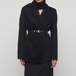 Front view of black calitra jacket on model in black skirt, against a white background.
