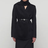 Front view of black calitra jacket on model in black skirt, against a white background.