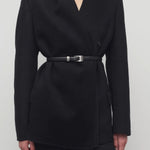 Front closeup view of black calitra jacket on model wearing black skirt, against a white background.