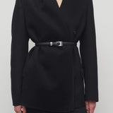 Front closeup view of black calitra jacket on model wearing black skirt, against a white background.