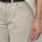 Closeup view of ice carlyl pant on model wearing white t-shirt and black belt, against a white background.